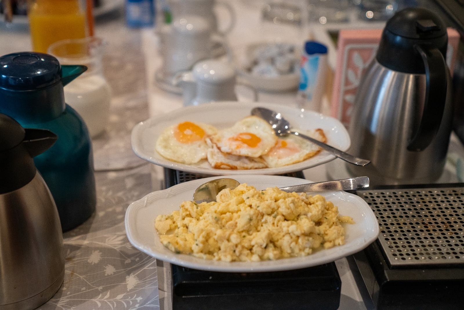 Scrambled and fried eggs on warming plates